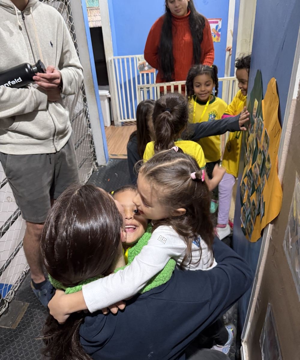 A child hugging a Rise Up Co member during a visit